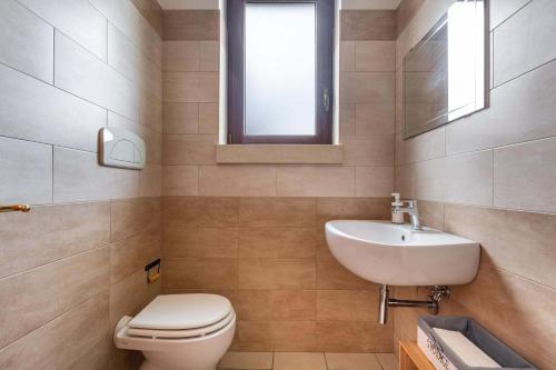 a bathroom with a toilet and a sink and a mirror at Villa La Paiara by Perle di Puglia in Borgagne