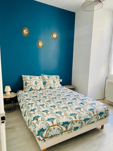 Schlafzimmer mit einem Bett mit blauer Wand in der Unterkunft Le Moderne in Issoudun