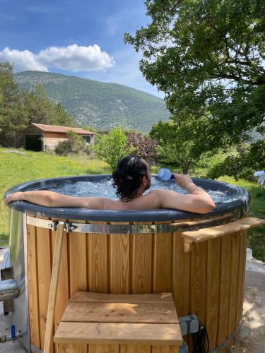 a woman in a jacuzzi in a yard at Gîte "Bois-Mariage" in Mollans-sur-Ouvèze