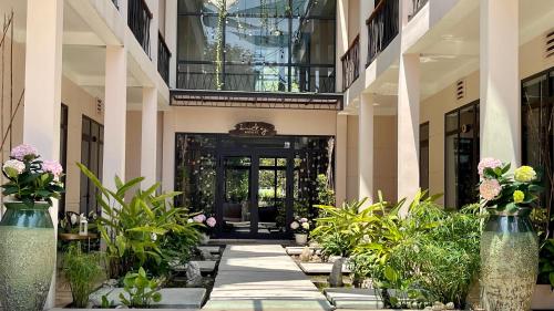 an entrance to a building with plants and flowers at PHOENIX MINH CHÂU HOTEL in Quang Ninh