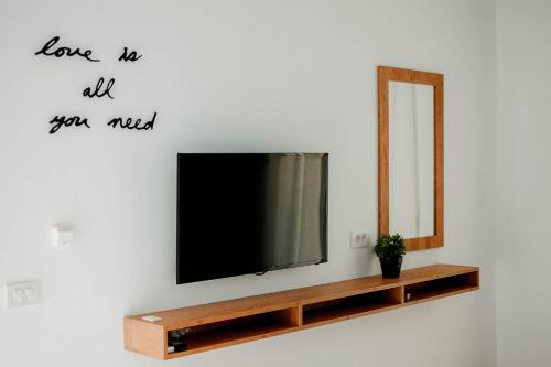 a television on a wall next to a mirror at Ideal House in Parga