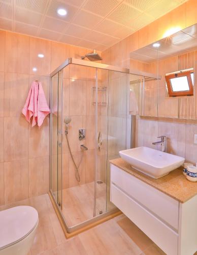 a bathroom with a shower and a sink and a toilet at Kuytu Kaş Houses in Kaş