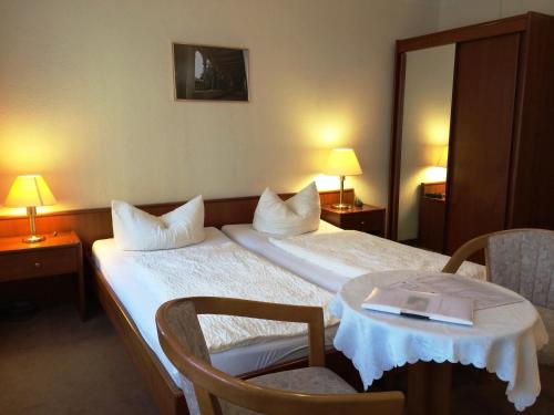 une chambre d'hôtel avec un lit et une table avec un livre. dans l'établissement Pension an der Havelbucht, à Potsdam