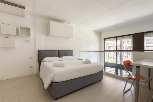 a bedroom with a bed and a table and a desk at Elegant Loft with Balcony! in Milan
