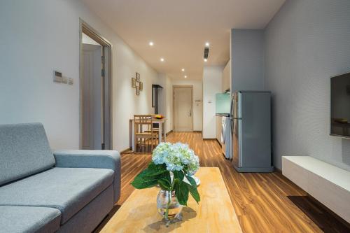 a living room with a couch and a vase of flowers at Ficus Suites in Hanoi