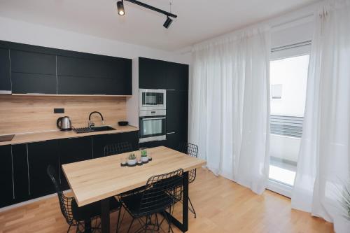 eine Küche mit einem Holztisch und Stühlen in der Unterkunft Apartman Tema in Podstrana