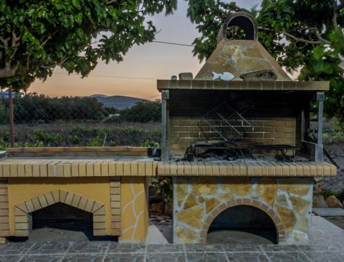 a stone pizza oven sitting on top of a patio at G & M Beach House in Haraki