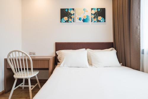 a bedroom with a bed and a chair and a desk at Ficus Suites in Hanoi