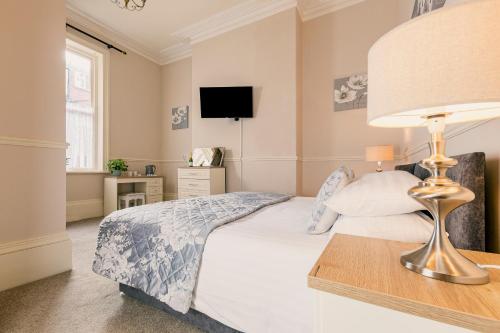 a bedroom with a bed with a lamp and a tv at The Maynard in Scarborough