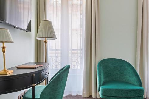 Cette chambre dispose d'un bureau, de deux chaises, d'une table et d'une fenêtre. dans l'établissement Hôtel de Sèvres, à Paris