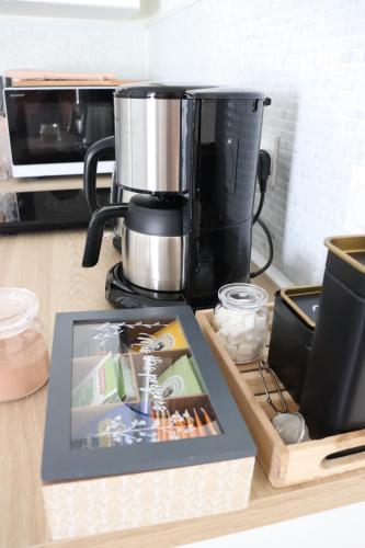 a kitchen counter with a coffee maker and a book at La Petite Boire - Chambres d'hôtes près d'Angers in Mûrs-Érigné