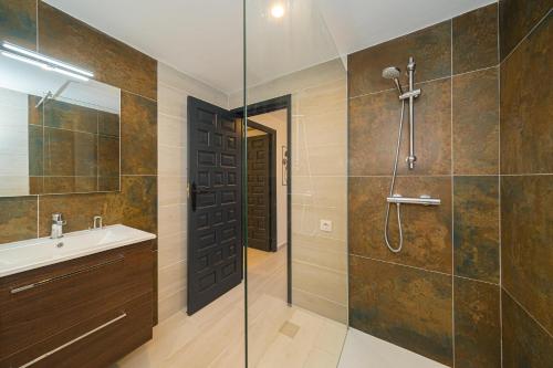 baño con ducha, lavabo y puerta de cristal en Casa de mi Padre Full Access en Casas de Torrat