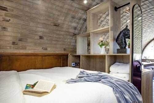 een slaapkamer met een bed met een boek en een spiegel bij The Charm Inn, The Little Burrow, Nr Wells in Radstock