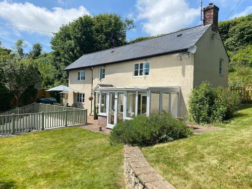 a white house with a fence and a yard at ‘The Nest’ A beautiful cottage in Devon in Axminster