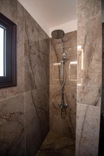 a bathroom with a shower with a stone wall at Luxury Villa Agathoula in Protaras