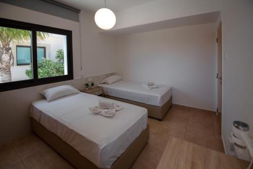 a bedroom with two beds and a window at Luxury Villa Agathoula in Protaras