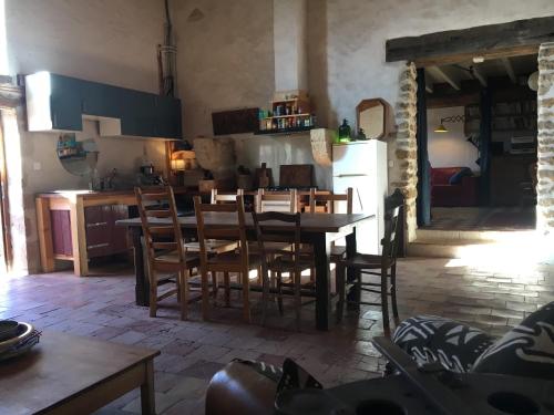 eine Küche und ein Esszimmer mit einem Tisch und Stühlen in der Unterkunft Jolie maison ancienne adaptée aux petits groupes calmes - Maison Peyri 