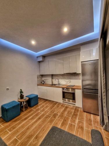 a kitchen with stainless steel appliances and blue stools at Coastline of Paradise in Paránimfoi