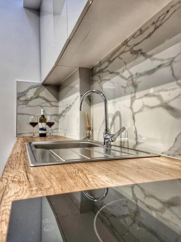 a kitchen with a sink and two glasses of wine at Coastline of Paradise in Paránimfoi