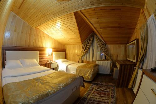 1 dormitorio con 2 camas y techo de madera en Gelgor Hotel, en Ayder