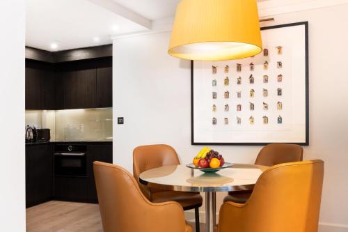 a dining room with a table and chairs at 15 Basil Street Knightsbridge, Luxury Serviced Apartments in London