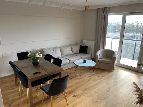 a living room with a couch and a table and chairs at Sucha Street Apartments, Nowa Letnica,Gdańsk in Gdańsk