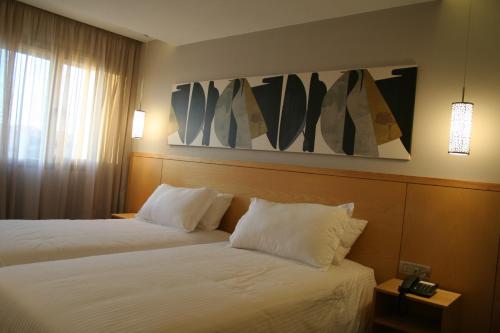 a hotel room with two beds and a painting on the wall at Valley Boutique Hotel in Safi