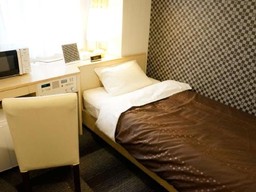 京都市にあるホテルリブマックスBUDGET京都五条のベッド1台、電子レンジが備わる小さな客室です。