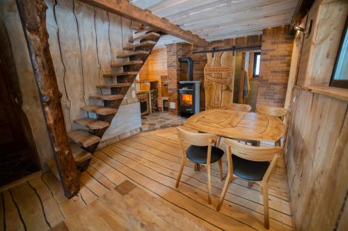 una mesa de madera y sillas en una habitación con una escalera de caracol en Tuimõisa Puhketalu en Tuimõisa