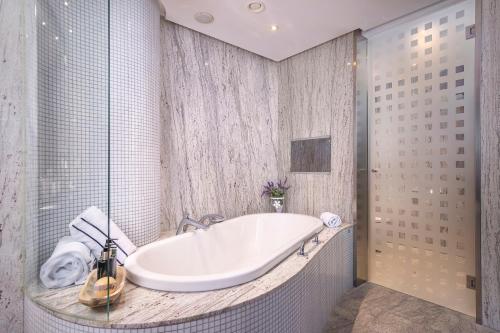 a white tub in a bathroom with a shower at Melia Valencia in Valencia