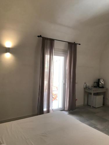 a bedroom with a bed and a large window at Dimora delle Tonnare in Favignana