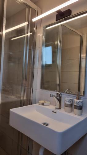 a bathroom sink with a mirror and a shower at Secret Garden Hotel in Maleme