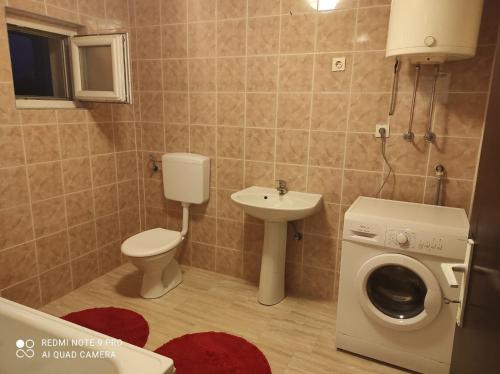 a bathroom with a toilet sink and a washing machine at Meri rooms in Bihać