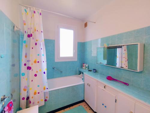 uma casa de banho com uma banheira e uma cortina de chuveiro em Villa Dziunia Jardin Terrasse ok em Tarnos