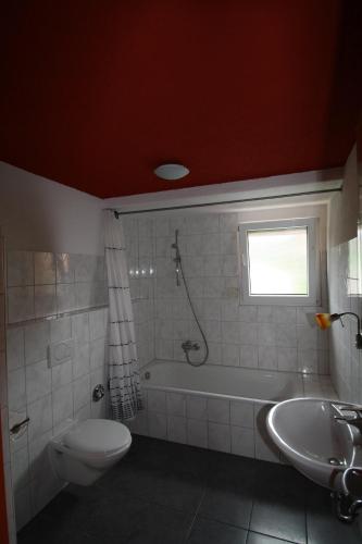 a bathroom with a tub and a toilet and a sink at Ferienwohnung Haus Ella in Neunkirchen