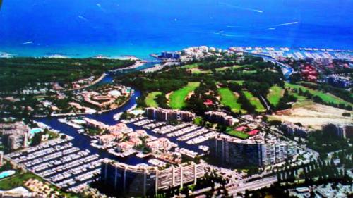 - une vue aérienne sur une ville avec des bâtiments et l'océan dans l'établissement F3 ILE MARINA MANDELIEU LA NAPOULE, à Mandelieu-la-Napoule