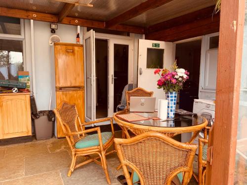 a patio with a table and chairs and a laptop at East of Ipswich Bed and Breakfast - Private & Dorm Rooms Suffolk in Ipswich