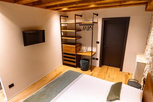a bedroom with a bed and a tv on a wall at B&B Casa del Vicario in Fagagna