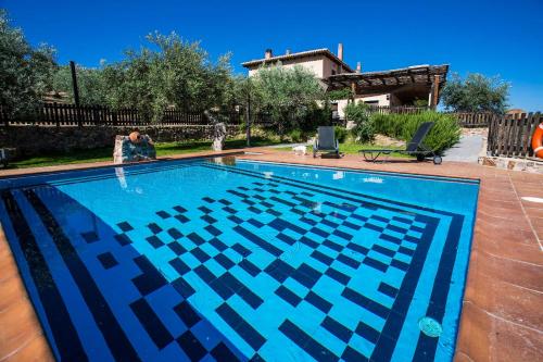 a swimming pool with a blue and black pattern on it at Casa rural la huerta de los nogales in Herrera del Duque