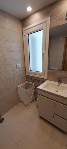 a bathroom with a sink and a toilet and a window at Piso Covian in Ribadesella