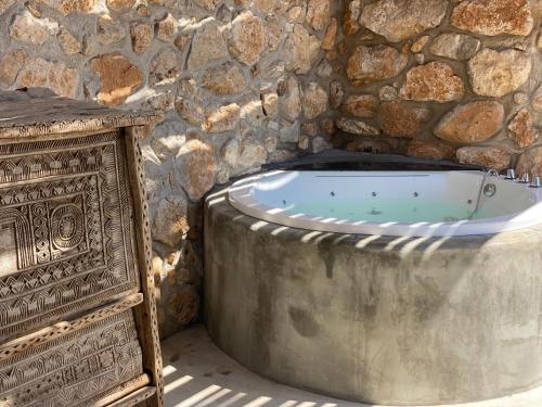 uma banheira num quarto de pedra com uma parede de pedra em Container Suite em Terrasini