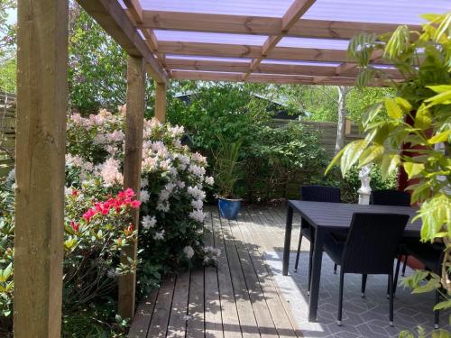 a patio with a table and a wooden pergola at Skagen hytte in Skagen