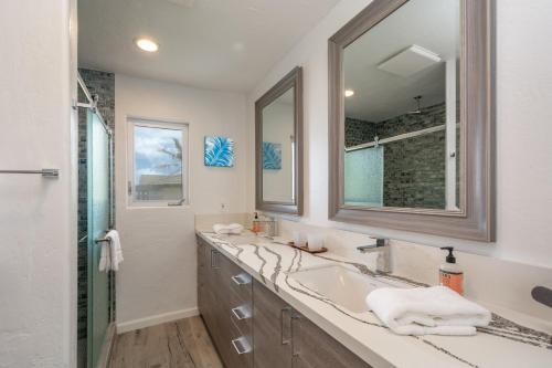 La salle de bains est pourvue d'un lavabo et d'un miroir. dans l'établissement Bond House home, à Anahola