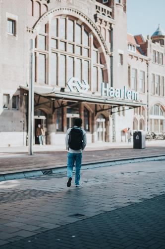 a man walking down a street in front of a building at Stayokay Hostel Haarlem in Haarlem