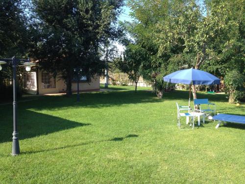 a table and chairs and an umbrella in a yard at Il Girasole Terzuolo in Manciano