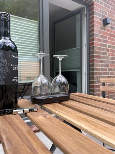 a bottle of wine and two glasses on a picnic table at Apartmenthaus Stade Schwingewiesen Apartment 2 in Stade
