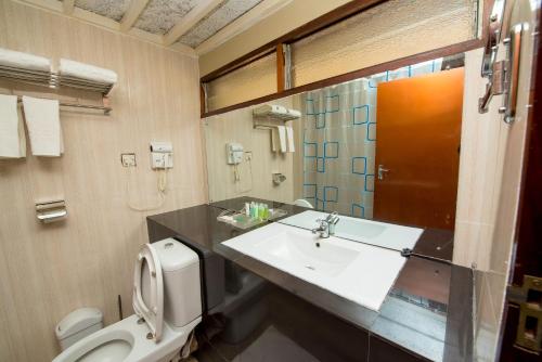 La salle de bains est pourvue d'un lavabo et de toilettes. dans l'établissement Kambiri Beach by Serendib, à Senga