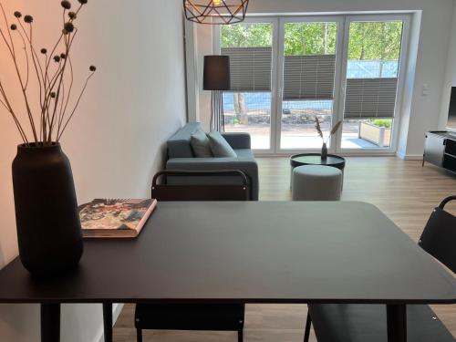 a living room with a table and a couch at Apartmenthaus Stade Schwingewiesen Apartment 3 in Stade