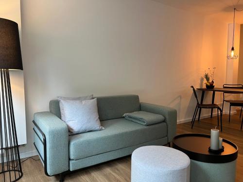 a living room with a green couch and a table at Apartmenthaus Stade Schwingewiesen Apartment 4 in Stade