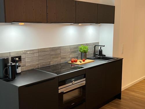 a kitchen with a black counter and a sink at Apartmenthaus Stade Schwingewiesen Apartment 5 in Stade